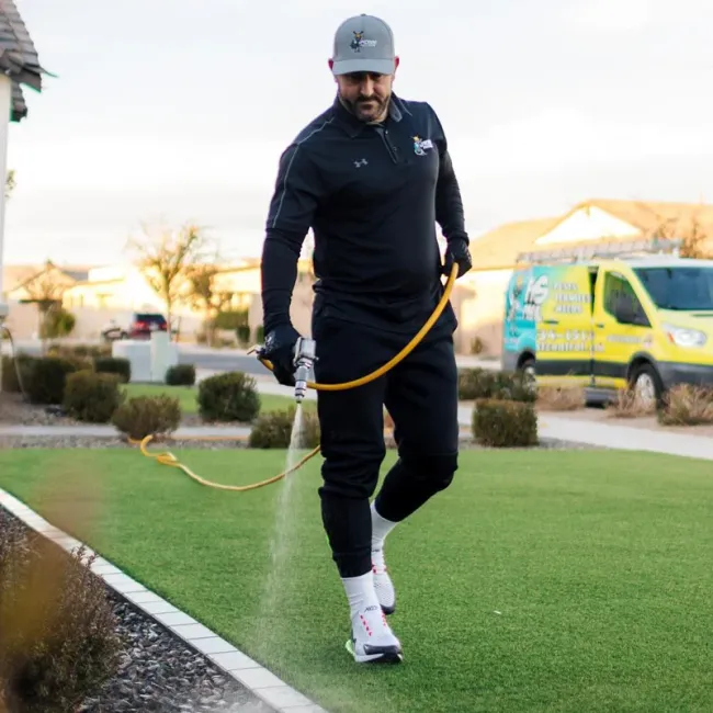 technician spraying weeds in flower bed