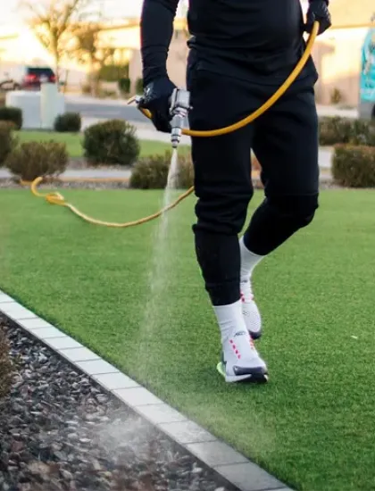 technician spraying weeds in flower bed